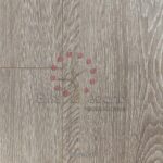 Superficie Piso Laminado Bruma con incrustación decorativa de un árbol y puntos rojos.