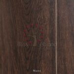 Superficie de madera con un diseño de árbol en relieve rodeado de cuentas rojas y con el texto impreso "Piso Laminado Nuez - pisos, maderas" indicando una marca de piso o productos de madera.