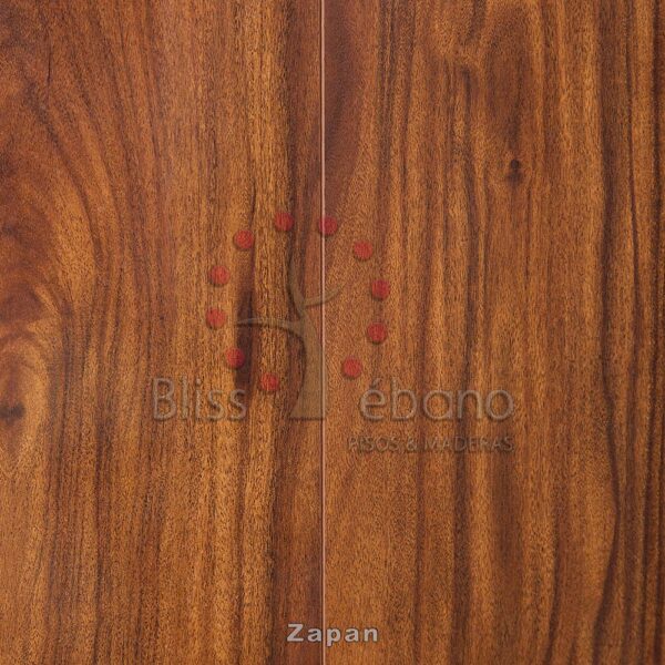 Primer plano de una superficie de Piso Laminado Zapan con un patrón de vetas de madera visible y una pequeña etiqueta numerada o marca.