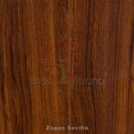 Superficie de madera con diseño de Piso Laminado Zapan Sevilla y etiquetas de texto, probablemente una muestra de piso o enchapado de madera con elementos de marca.