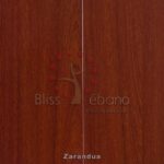Superficie de madera con los logos grabados "bliss" y "ébano pisos & maderas" junto con un diseño de árbol estilizado adornado con pequeños puntos rojos de Piso Laminado Zarandua.