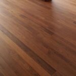 Una espaciosa sala con Piso de Madera Zapan, grandes ventanales y una mesa de billar cubierta en la esquina.