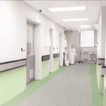 Moderna habitación de hospital con Piso en Rollo Arena y cama vacía.