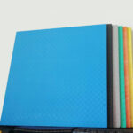 Pila de coloridas colchonetas de ejercicio Piso Tableta de Caucho Colores sobre un fondo blanco.