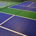 Canchas de tenis cubiertas con superficies de Piso de Polipropileno Tenis azules y verdes y líneas blancas visibles que marcan los límites.