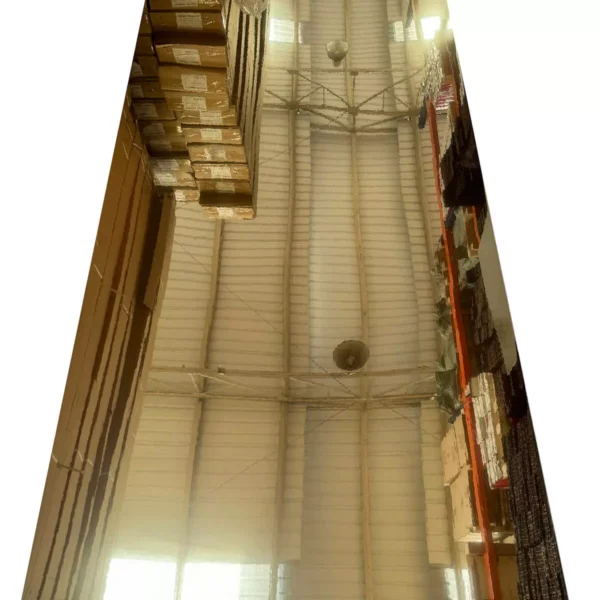 Vista de un almacén de techo alto con múltiples estantes apilados con cajas y productos a lo largo de las paredes.