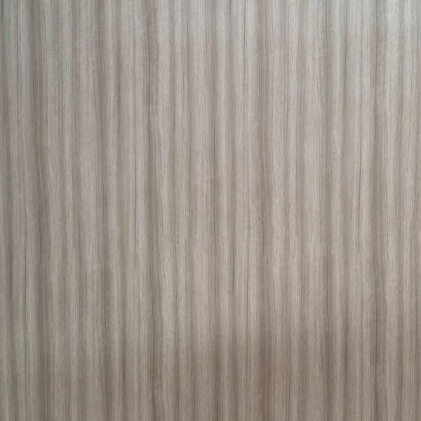 Primer plano de una superficie beige con textura similar a la madera y líneas verticales: Lámina PVC para paredes.