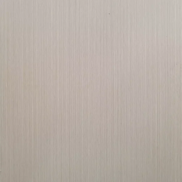 Un primer plano de una pared beige con una sutil textura vertical realizada con Lámina PVC para paredes.