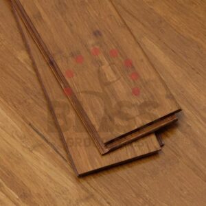 Tres tablas de suelo de bambú apiladas una sobre otra, expuestas sobre una superficie de suelo de bambú a juego.