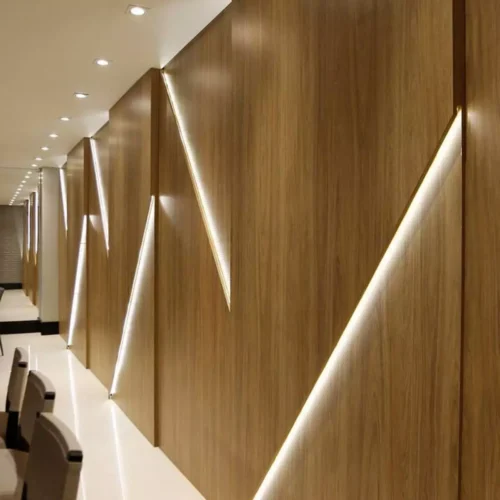 Un pasillo moderno con Lámina PVC para paredes iluminado mediante iluminación empotrada.